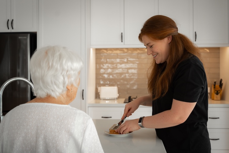 lady assisting elder lady to make lunch in residential care