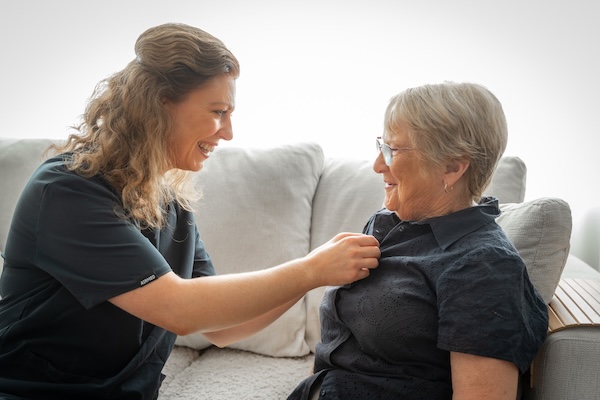 emergency age care support lady helping an older lady with her clothes