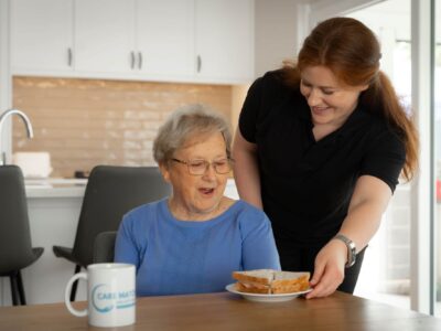 Nurse helping elderly woman after Australian aged care reforms