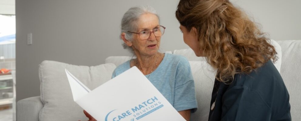 assistant reading age care brochure to old lady